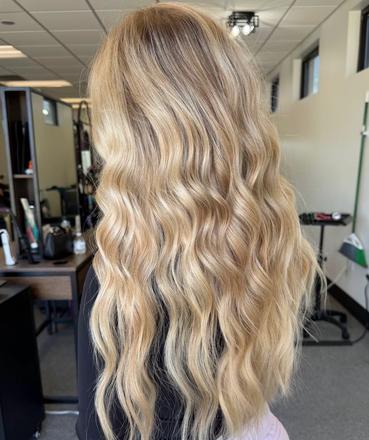 Long blonde wavy hair with dimensional color from Oh Baby Salon and Spa in Bloomington, Illinois