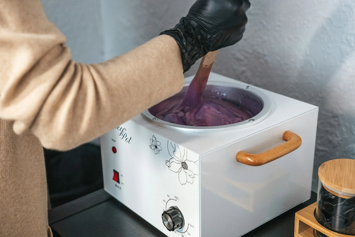 Wax being stirred in a wax warmer at Oh Baby Salon and Spa in Bloomington, Illinois